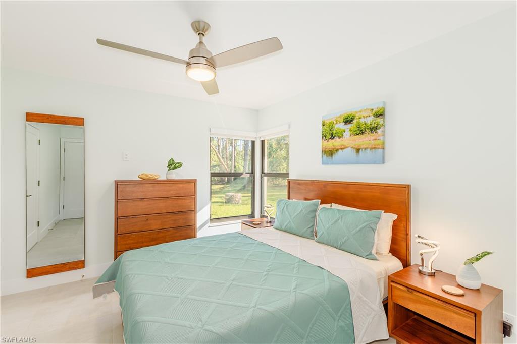 3511 17th Avenue Southwest Naples, FL 34117 - Photo 19 of 32 a bedroom with a bed and a chandelier