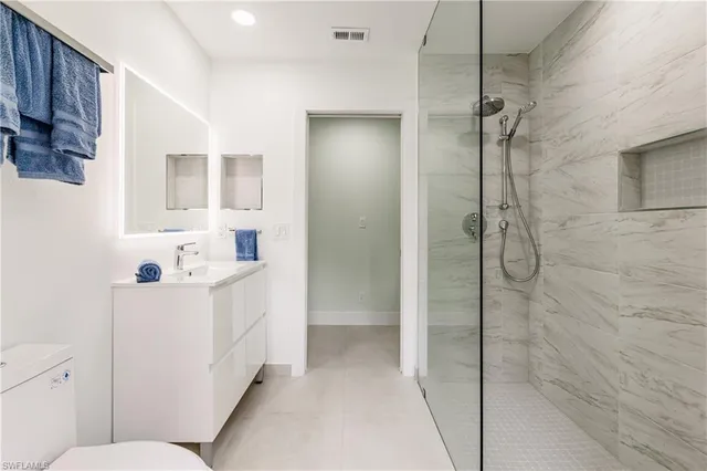 a bathroom with a sink a toilet and shower