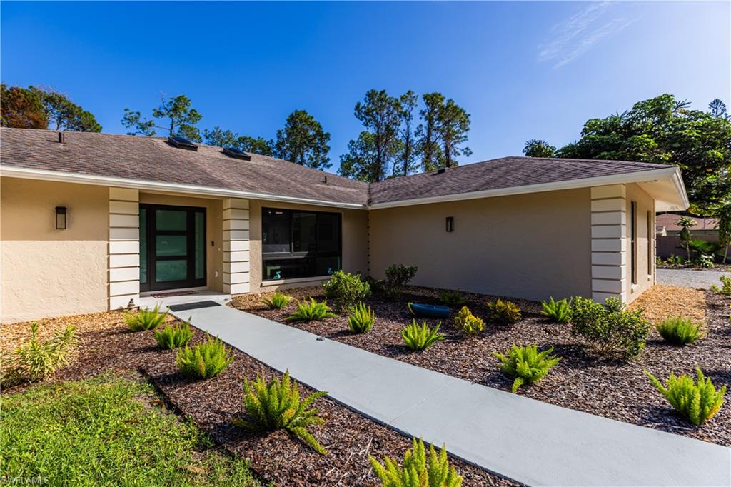 3511 17th Avenue Southwest Naples, FL 34117 - Photo 4 of 32 a front view of a house with a yard
