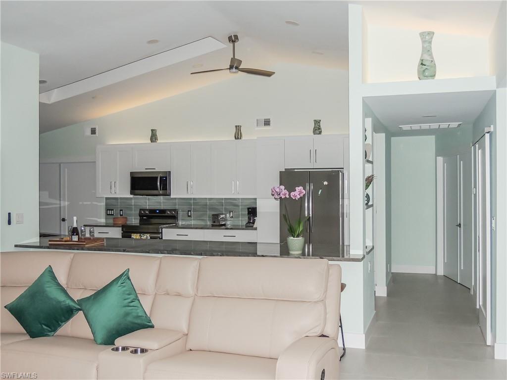 3511 17th Avenue Southwest Naples, FL 34117 - Photo 9 of 32 a kitchen with stainless steel appliances kitchen island granite countertop a refrigerator and a sink