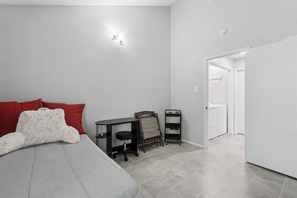 9780 Windy Ridge Road Frisco, TX 75033 - Photo 17 of 25 Light gray walls and tiled flooring define this room, featuring a wall-mounted light fixture and a tall ceiling