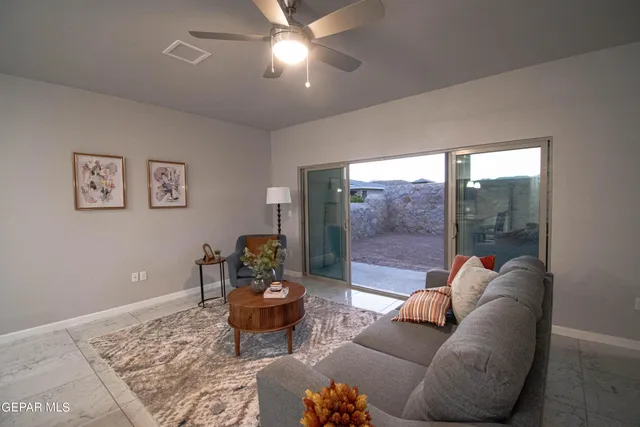 a living room with furniture and a floor to ceiling window