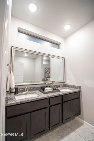 a bathroom with a granite countertop sink and a mirror