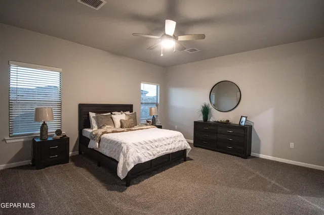 a bedroom with a bed window and dresser