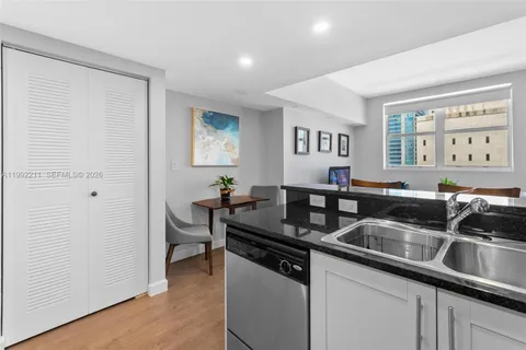 a kitchen with stainless steel appliances granite countertop a sink and a refrigerator