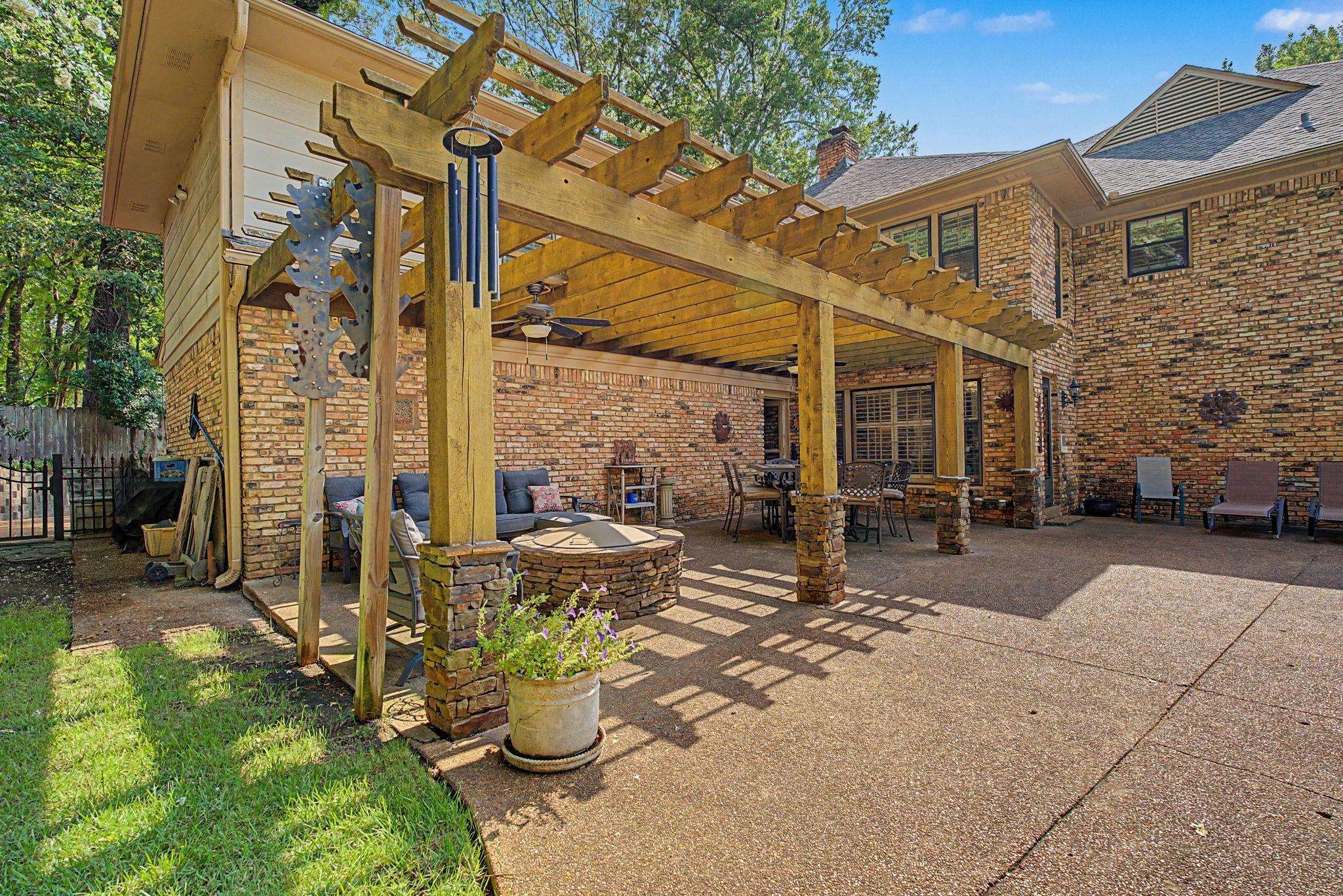 1929 Miller Farms Road Germantown, TN 38138 - Photo 35 of 40 Expansive outdoor entertaining area featuring a large pergola with ceiling fans, a built-in stone fire pit, and a brick and stone exterior