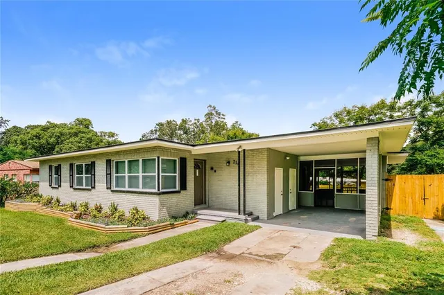 a front view of a house with a yard and potted plants