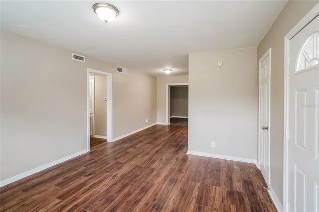 a view of an empty room with wooden floor