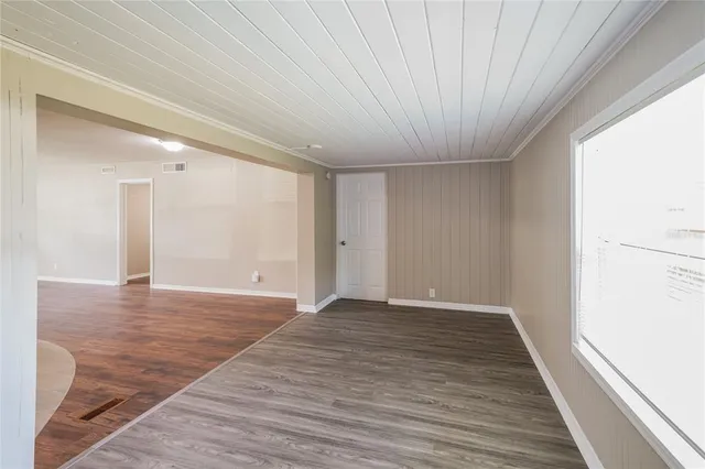 a view of an empty room with wooden floor