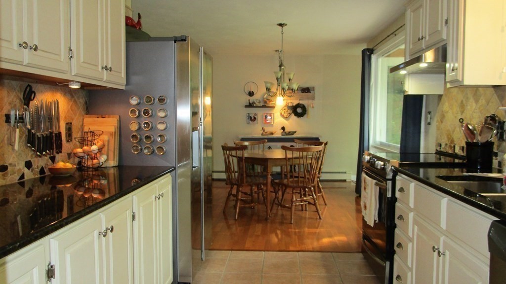 52 Pine Ridge Road Montgomery, MA 01085 - Photo 5 of 39 a kitchen with stainless steel appliances kitchen island granite countertop a table and chairs in it
