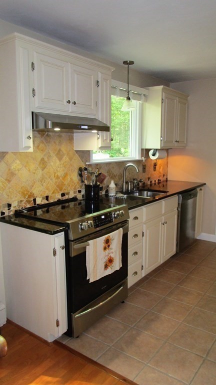 52 Pine Ridge Road Montgomery, MA 01085 - Photo 6 of 39 a kitchen with stainless steel appliances granite countertop a stove a sink and white cabinets