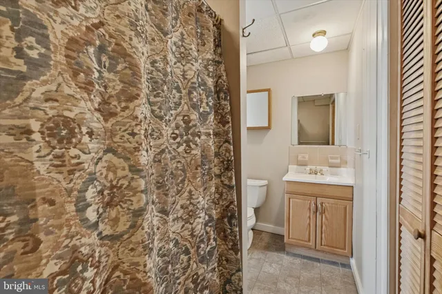 a bathroom with a sink and mirror with toilet