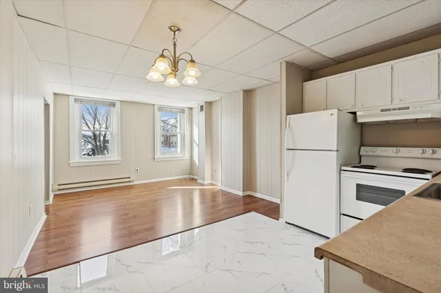 a view of a kitchen with a sink refrigerator and a stove top oven
