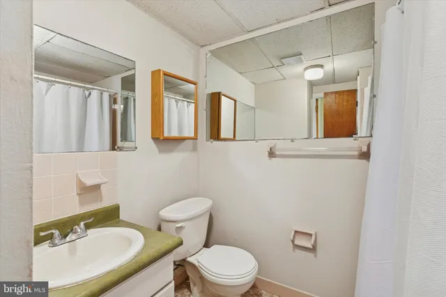 a bathroom with a sink a mirror a toilet and shower