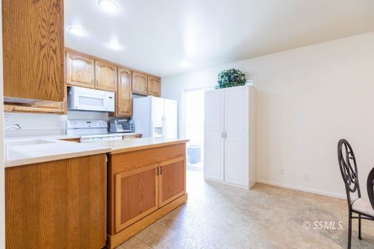 1016 Peg Street Ridgecrest, CA 93555 - Photo 9 of 26 a kitchen with stainless steel appliances granite countertop a refrigerator sink and white cabinets