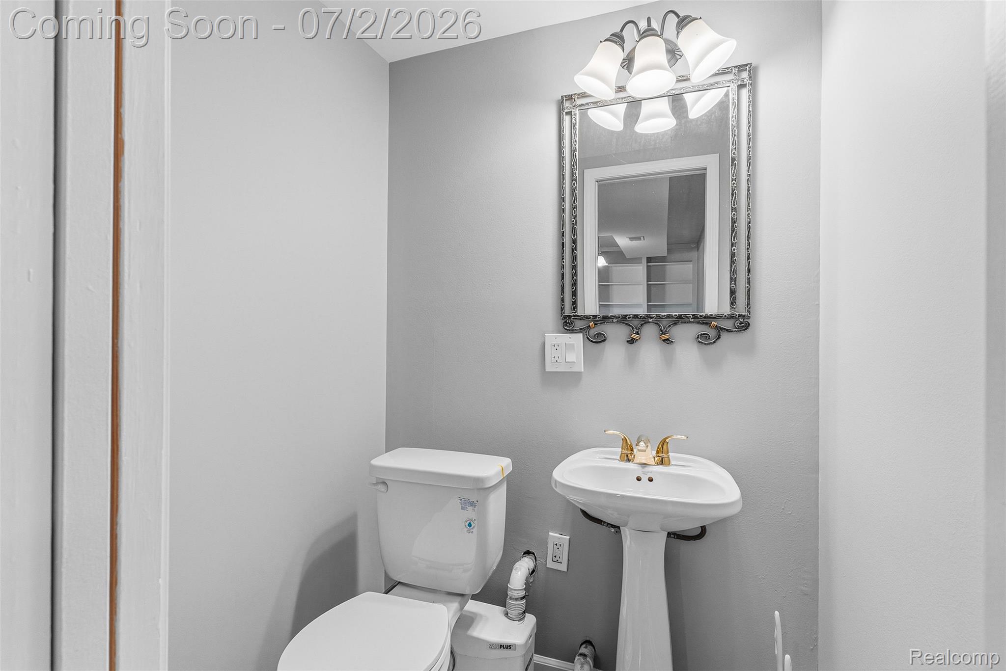305 East Road Holly, MI 48442 - Photo 26 of 41 Pedestal sink with brass-finish faucet, traditional wall mirror, and five-light vanity fixture