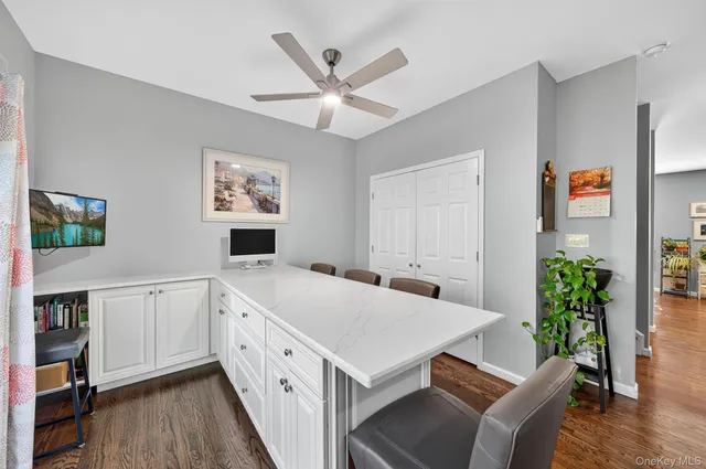 a kitchen with stainless steel appliances kitchen island granite countertop a refrigerator oven a sink dishwasher and white cabinets with wooden floor