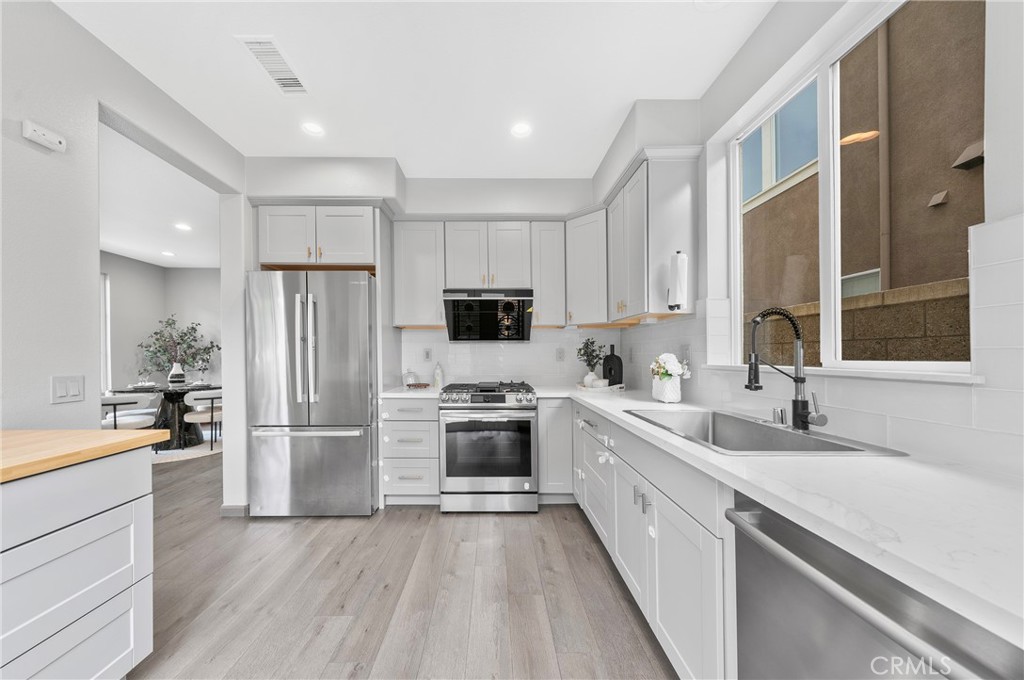 311 Nimbus Tustin, CA 92782 - Photo 15 of 39 a kitchen with white cabinets and stainless steel appliances