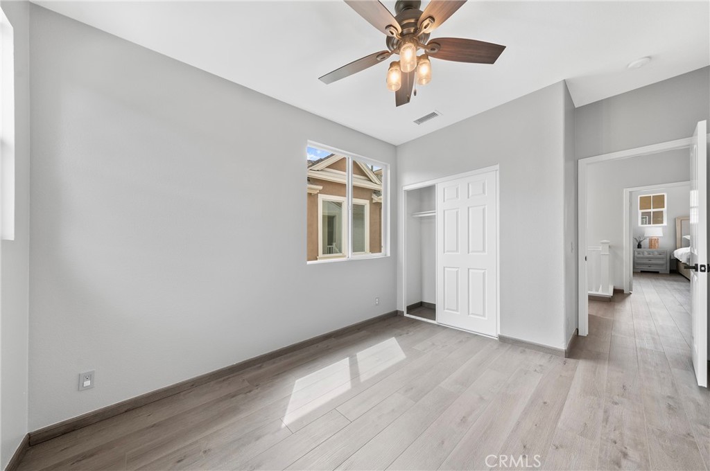 311 Nimbus Tustin, CA 92782 - Photo 25 of 39 an empty room with wooden floor chandelier fan and windows