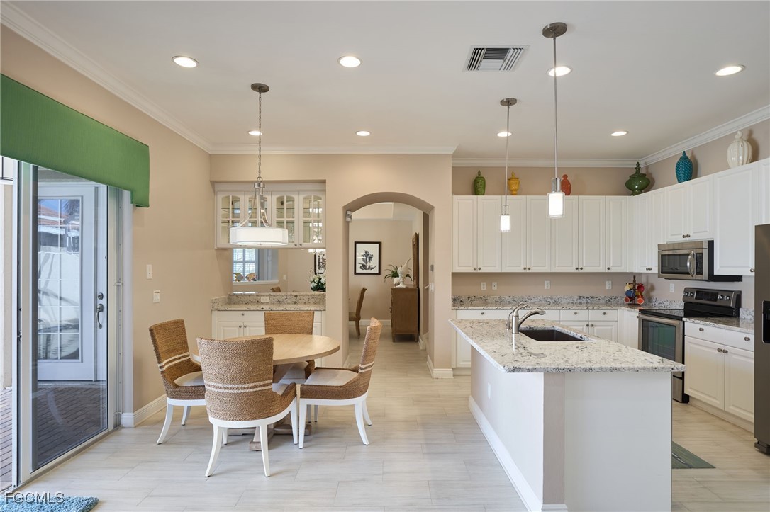 14101 Bently Circle Fort Myers, FL 33912 - Photo 7 of 29 a kitchen with a dining table chairs and refrigerator