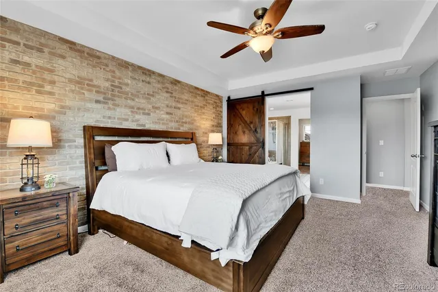 a bedroom with a bed and a lamp on a dresser