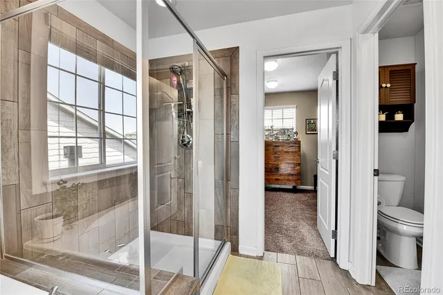 a bathroom with a glass shower door and a toilet