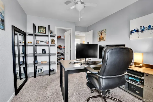 a view of a workspace with furniture and a window