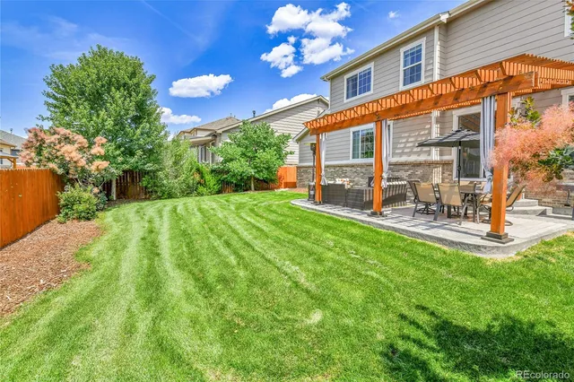 a view of a house with backyard and sitting area