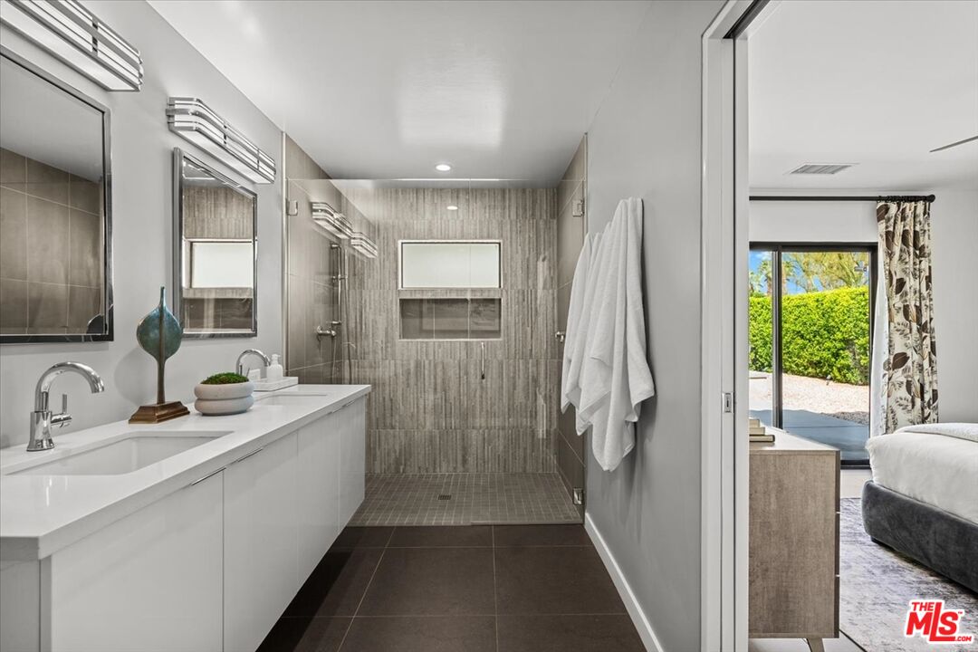 2994 Guadalupe Road Palm Springs, CA 92264 - Photo 20 of 33 a bathroom with a double vanity sink a mirror and a bathtub