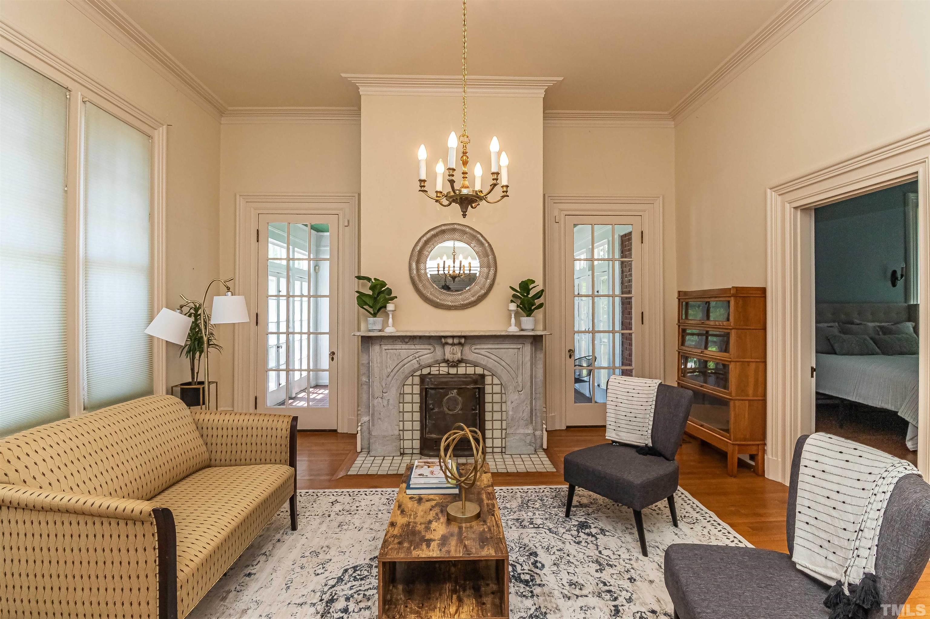 111 South George Street Goldsboro, NC 27530 - Photo 16 of 51 a living room with furniture a fireplace and a chandelier