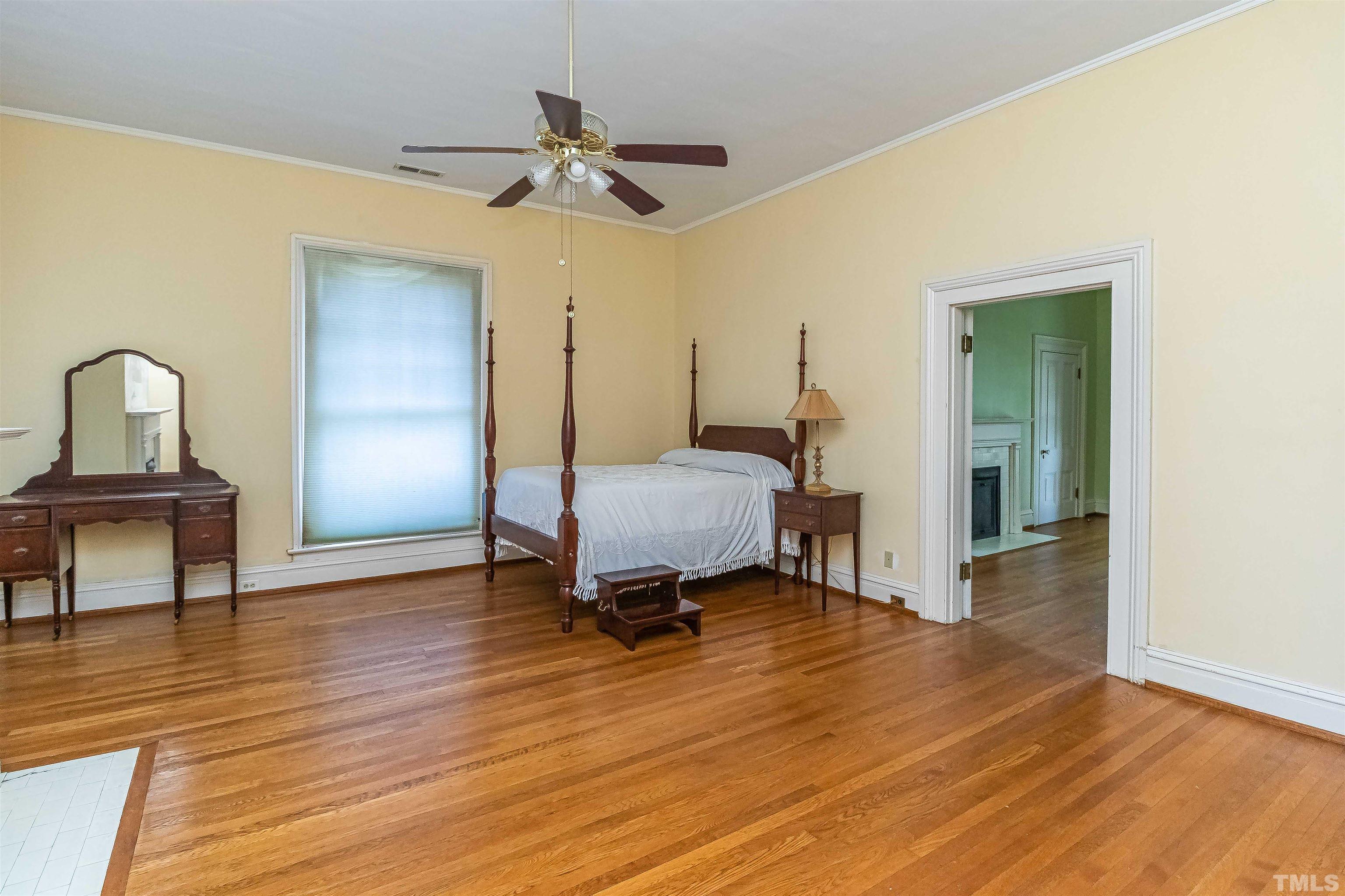 111 South George Street Goldsboro, NC 27530 - Photo 36 of 51 a bedroom with a bed and wooden floor