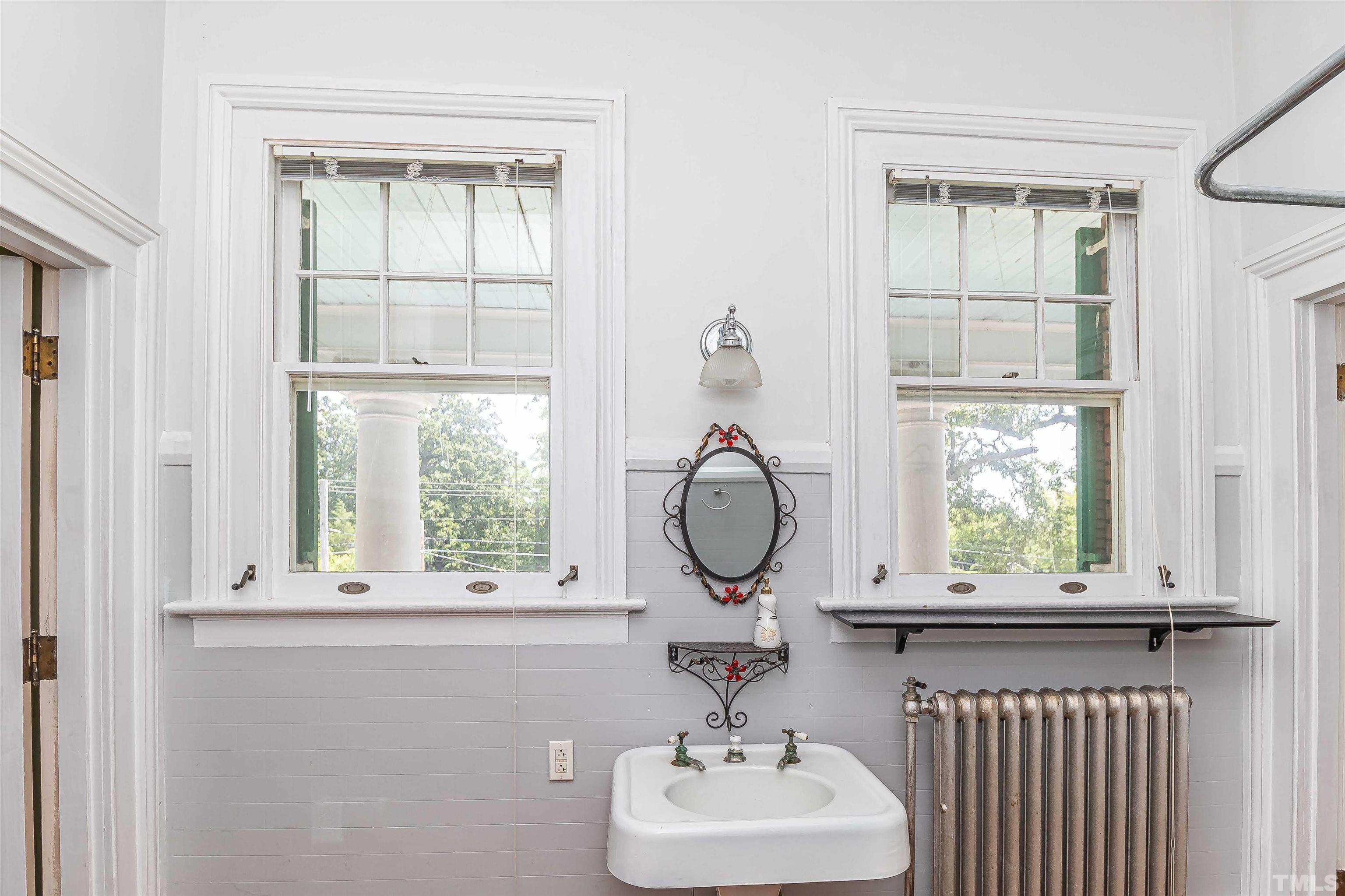 111 South George Street Goldsboro, NC 27530 - Photo 44 of 51 a bathroom with a window a sink and a mirror