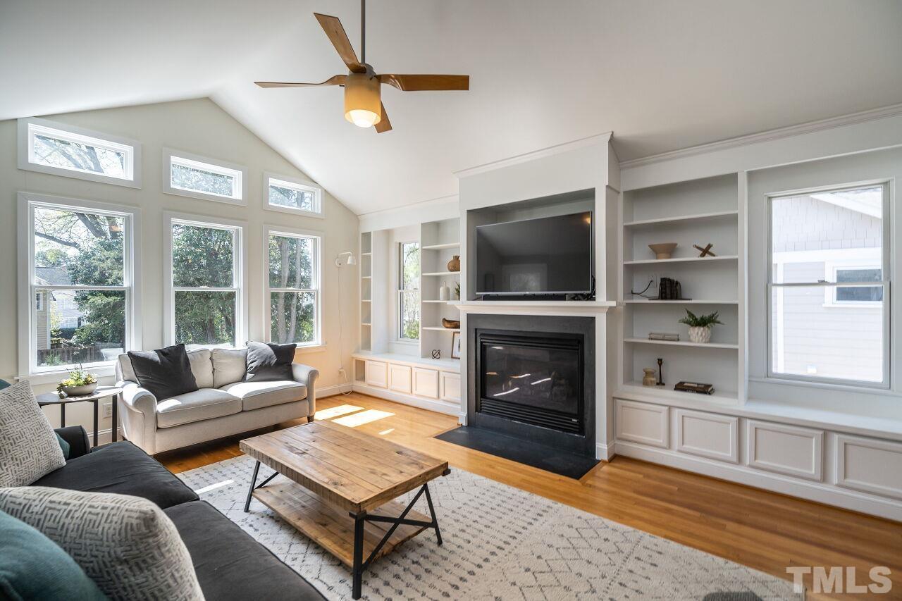 118 East Whitaker Mill Road Raleigh, NC 27608 - Photo 11 of 21 a living room with furniture a flat screen tv and a fireplace