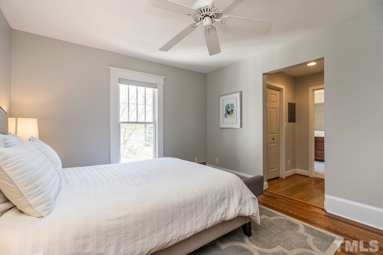 118 East Whitaker Mill Road Raleigh, NC 27608 - Photo 13 of 21 a bedroom with a bed and a chandelier