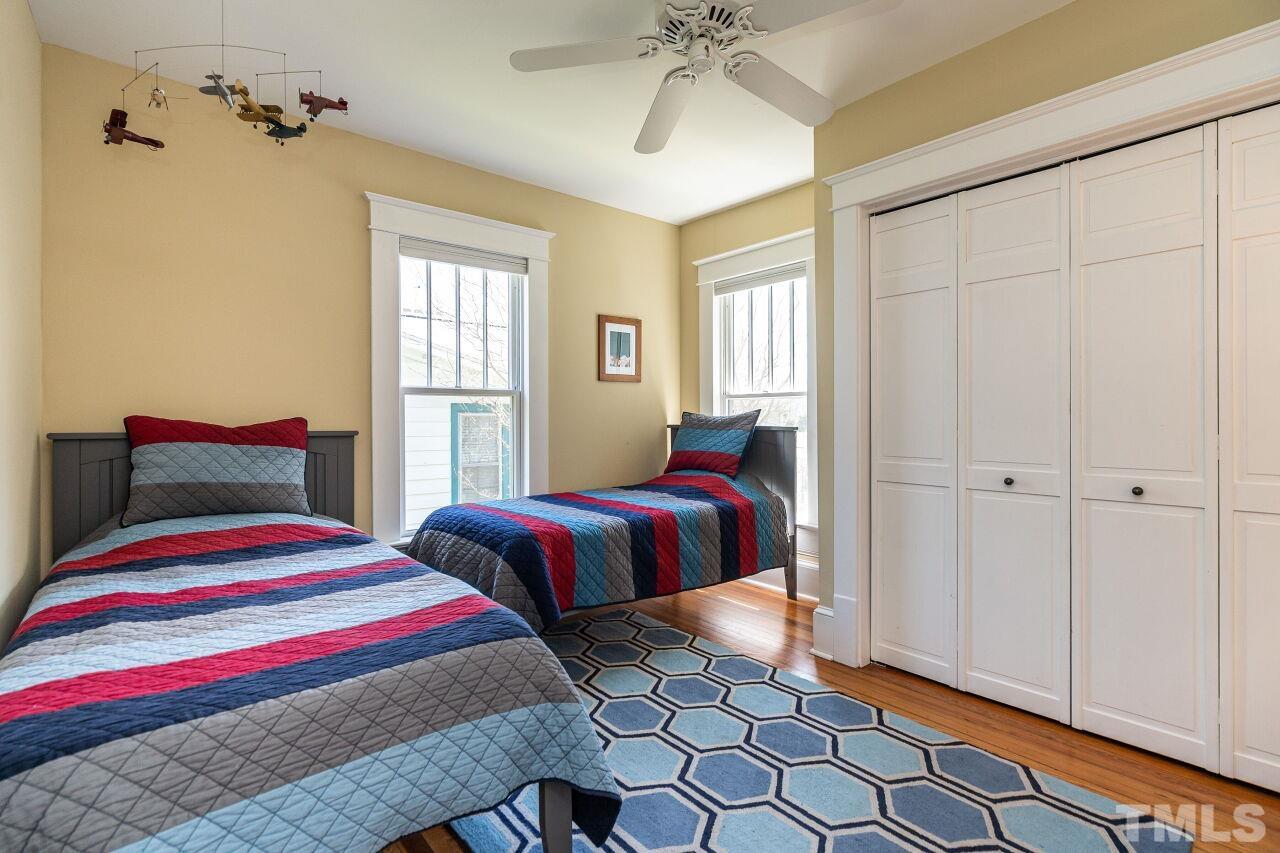 118 East Whitaker Mill Road Raleigh, NC 27608 - Photo 17 of 21 a bedroom with a bed and a chandelier