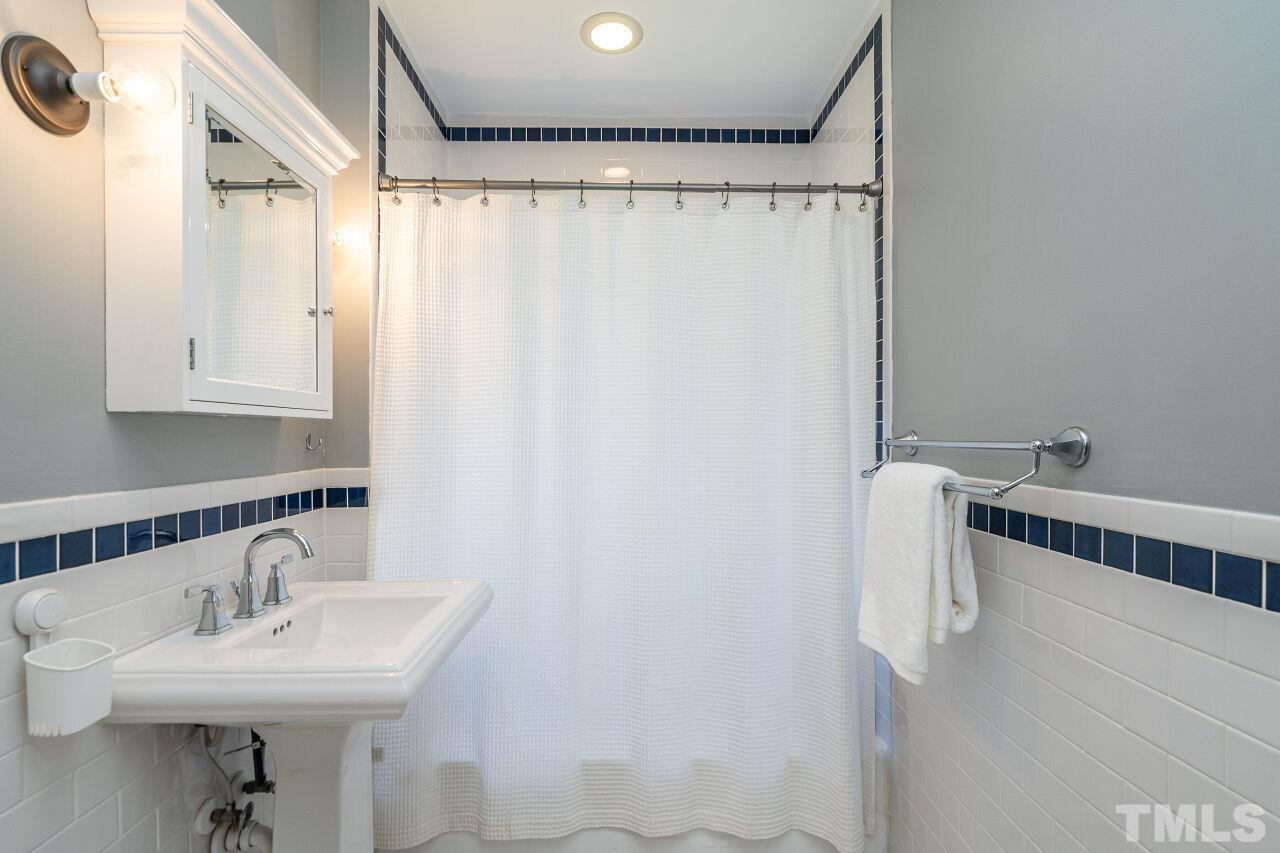 118 East Whitaker Mill Road Raleigh, NC 27608 - Photo 18 of 21 a bathroom with a sink a mirror and a shower