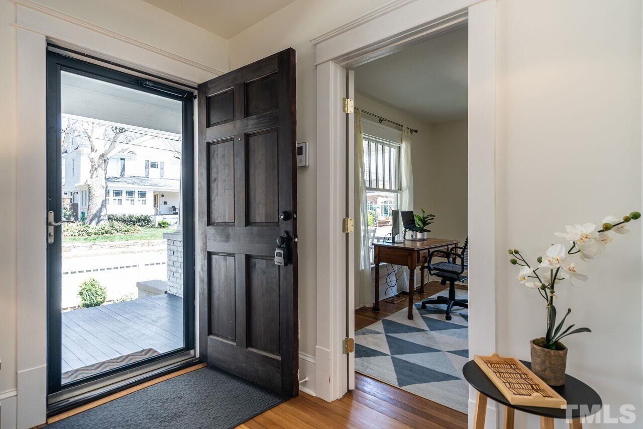 118 East Whitaker Mill Road Raleigh, NC 27608 - Photo 3 of 21 a view of a hallway with wooden floor and a livingroom with furniture