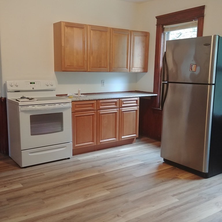 a kitchen with a refrigerator stove and wooden cabinets