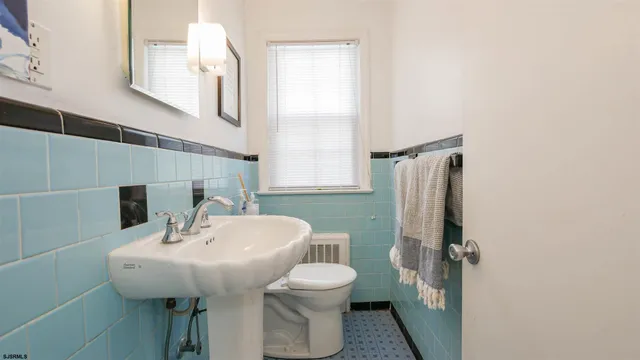 a bathroom with a sink a toilet and mirror