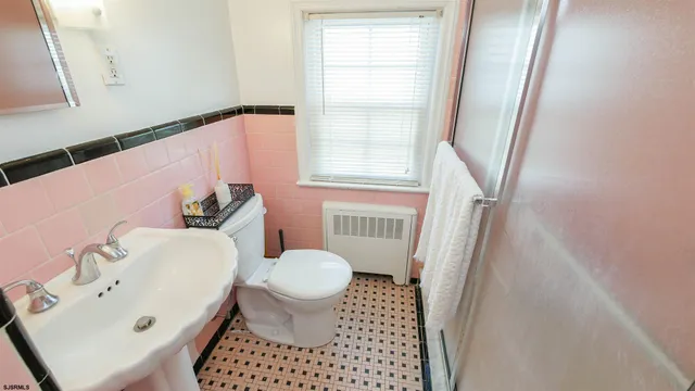 a bathroom with a sink toilet and window