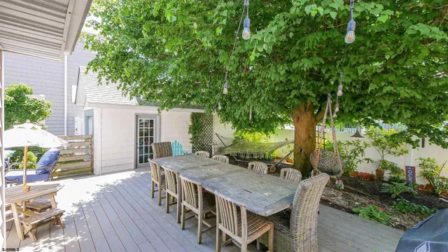 a view of a patio with table and chairs with wooden floor and fence