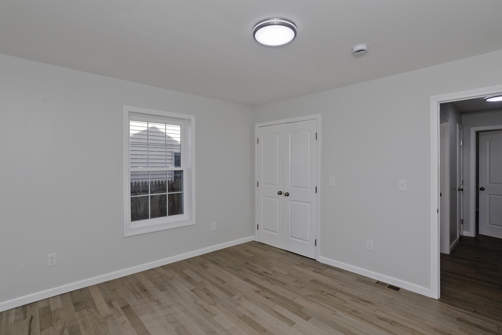 72 Lancaster Street Springfield, MA 01118 - Photo 22 of 35 an empty room with wooden floor and windows
