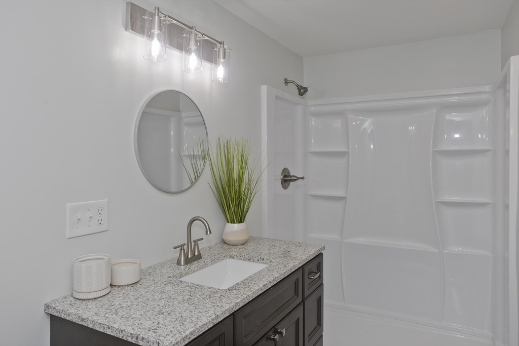 72 Lancaster Street Springfield, MA 01118 - Photo 30 of 35 a bathroom with a granite countertop sink a mirror and a shower