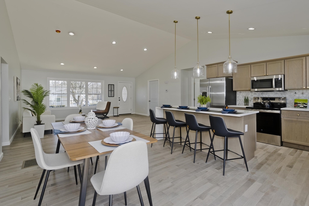 72 Lancaster Street Springfield, MA 01118 - Photo 4 of 35 a dining room with stainless steel appliances kitchen island granite countertop a dining table chairs and a refrigerator
