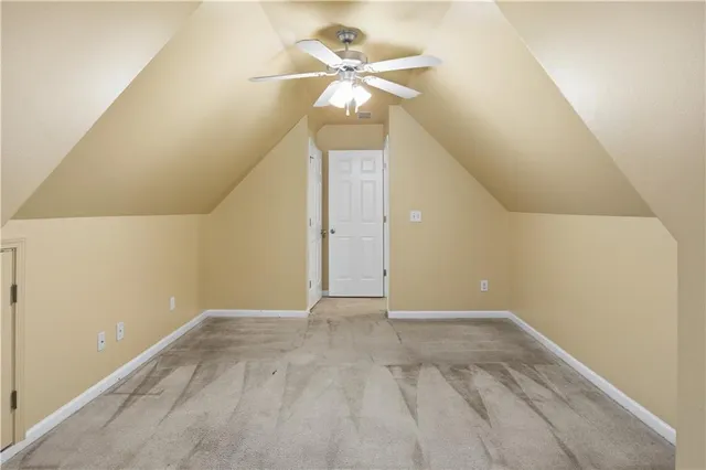 an empty room with windows and chandelier fan