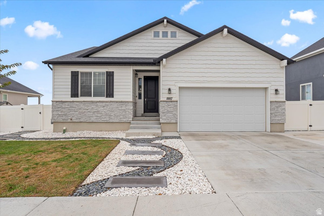 1887 Rock Hollow Road Lake Point, UT 84074 - Photo 1 of 1 View of front facade with stone siding, a gate, driveway, and a garage