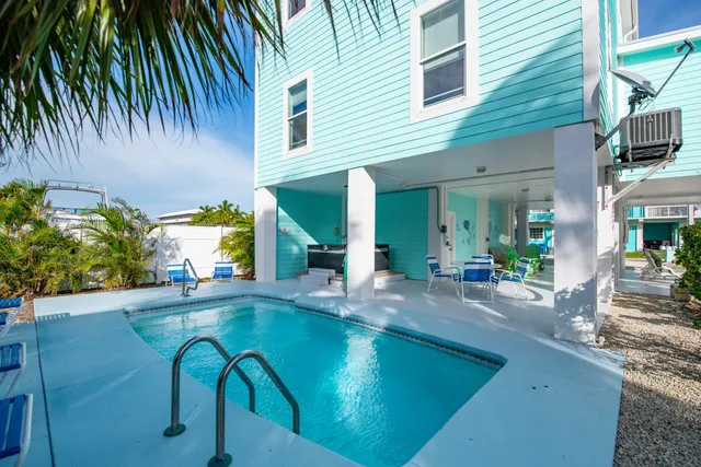 a view of a house with backyard swimming pool and sitting area