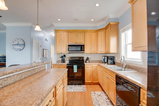 a kitchen with granite countertop a sink appliances cabinets and furniture