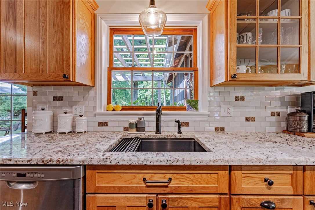 8062 Chagrin Road Chagrin Falls, OH 44023 - Photo 15 of 50 New granite countertops pair beautifully with original, recently refinished wood cabinetry—some featuring charming glass-front doors. Decorative backsplash provides the finishing touch. And with tranquil views just beyond the sink, even everyday tasks like washing dishes becomes a pleasure.
