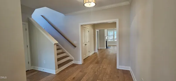 a view of a hallway with wooden floor and entryway